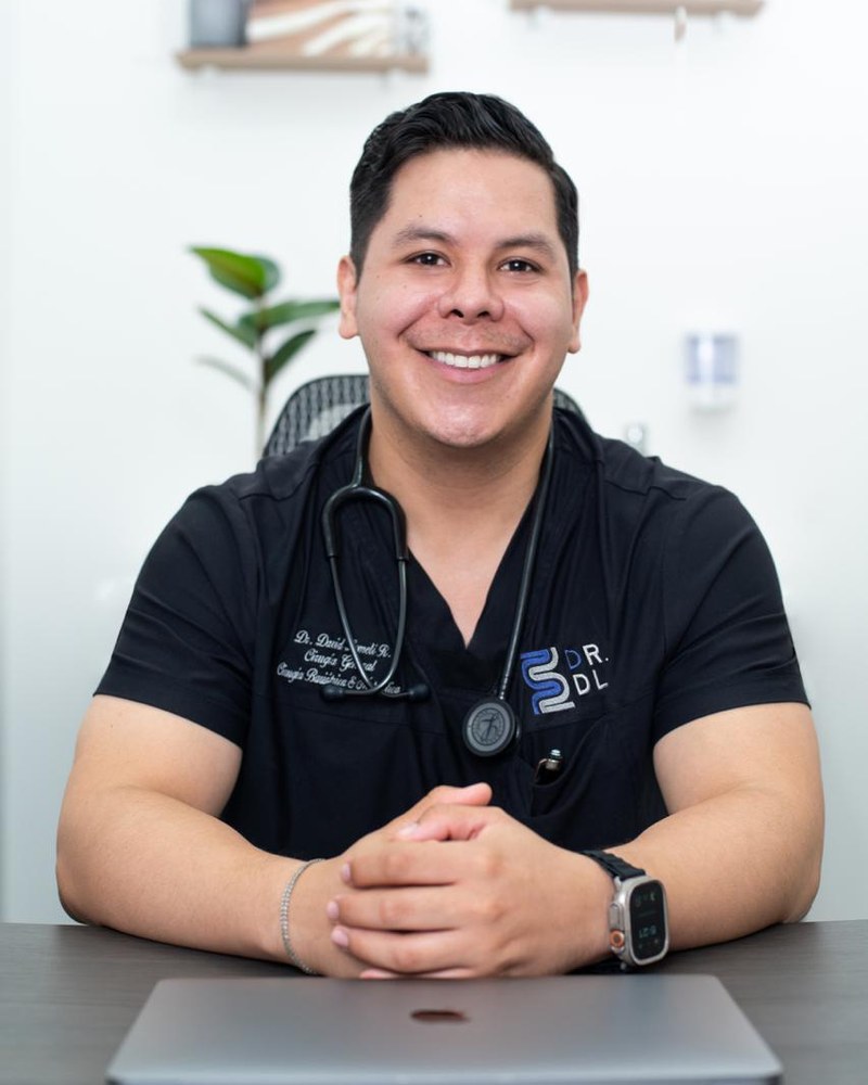 Dr. David Lomelí at his consultorio desk in Cancun
